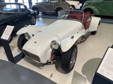 In het British Motor Museum staat een witte auto met een rood dak tentoongesteld.