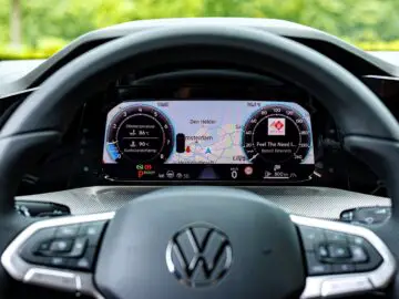 The dashboard of a VW Golf car displays a digital speedometer, navigation map and various driving information.