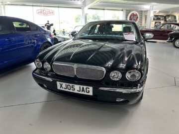 In a reportage-like setting, the showroom displays a black Jaguar car adorned with the license plate 