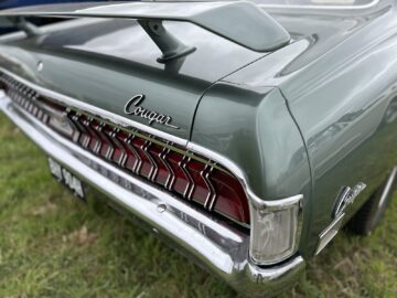 Close-up van het achterste gedeelte van een groene vintage Mercury Cougar-auto met opvallende achterlichten en een zichtbaar 'Cougar'-embleem, vastgelegd tijdens de West Oxon Steam Vintage Show 2024.