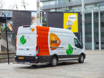 Almere, Netherlands—Mar 23, 2024:a Postnl mail car  in  Almere centrum ...